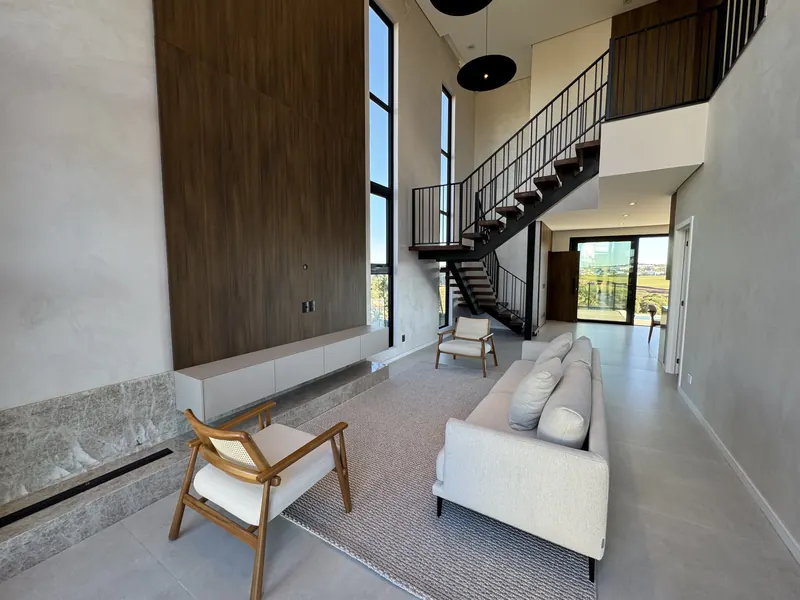 Sala de estar com pé-direito duplo e escada vazada